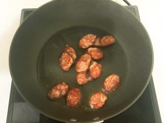 13、黑椒腊肠炒意面,锅里加入腊肠，翻炒1分钟