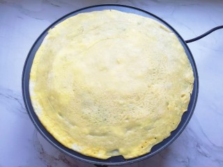 7、玉米渣煎饼,待蛋液凝固以后，将煎饼翻面。