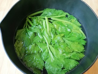 1、炸春卷,芹菜叶洗干净，小锅内放水加一点盐和食用油烧开，下入芹菜叶焯水至变色，捞出过凉水备用。