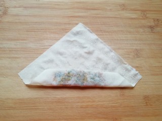 9、炸春卷,将有馅的一角卷起。