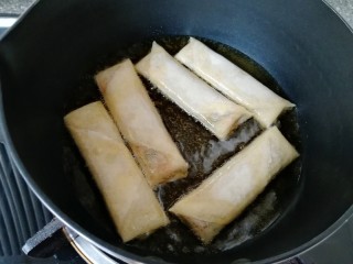 14、炸春卷,炸锅内倒入多一点菜籽油烧热，放入做好的春卷。