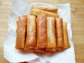 16、炸春卷,盘子里铺上厨房用纸，放上炸好的春卷。