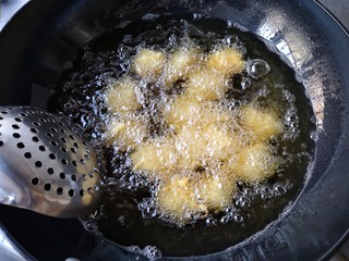 14、酥炸鱼翅南瓜丸子,炸定型后用漏勺轻轻推底。