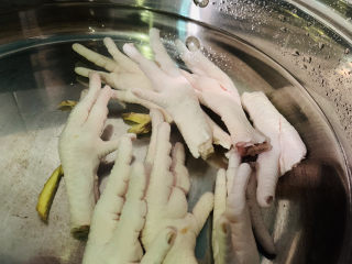 1、香辣卤鸡爪,锅里加清水加料酒加姜片,将清洗干净的鸡爪,冷水下锅;