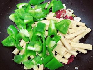 13、青椒炒腐竹,放入青椒翻炒均匀。