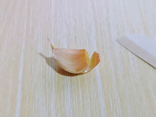 3、油炸金蒜子,用小刀将蒜瓣的根部切掉一点。