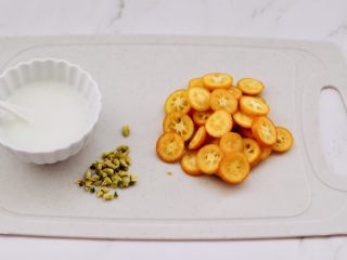 2、金桔圆子酒酿羹,把金桔洗净后，用刀把金桔切成薄片去核，淀粉加入少许清水化开备用。