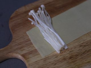 6、豆皮金针菇卷,取一片，放上适量金针菇