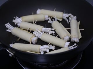 11、豆皮金针菇卷,锅里倒入少许油，放入豆皮金针菇煎制