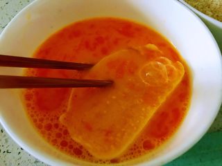 3、蒜香馒头片,鸡蛋打入碗中，放入一点点水，放入盐，用筷子搅开，用筷子夹起一个馒头片放入蛋液碗中，所有面全部粘上蛋液。