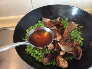 7、糖醋咸黄鱼毛豆,加入一勺料酒。煸炒一分钟。