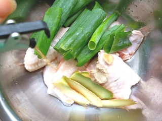3、压力锅焖奥尔良肉酱鸡翅,放入盆中，加入料酒，葱，姜