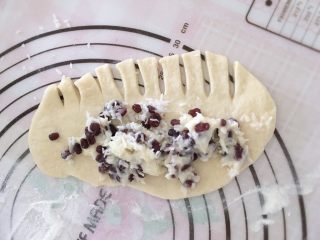 7、满屋飘香，吃过一次就爱上的椰蓉面包,把面团擀成长方形薄片，在薄片的另一边上用刮刀切一些小条，在上端涂上适量的沙拉酱、椰蓉和蜜豆