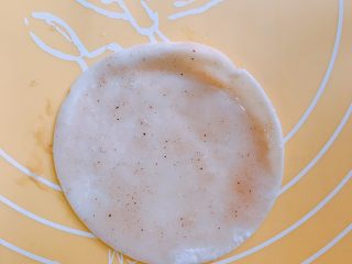 5、消耗饺子皮 葱油饼,先放一个饺子皮,刷上步骤四的油