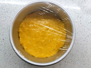 6、南瓜发糕,倒入6寸的活底模具，抹平表面，如果粘可以手背沾点油来抹。盖上保鲜膜发酵一小时，至2.5倍大。