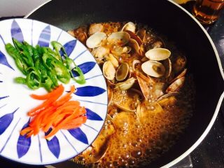 12、爆炒香辣花蛤,放入青椒丝和红椒丝翻炒均匀即可关火