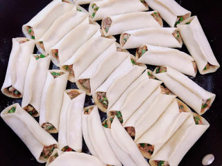 12、韭菜锅贴,锅中倒入油，将锅贴摆放在锅中。将锅贴底部煎至焦黄。