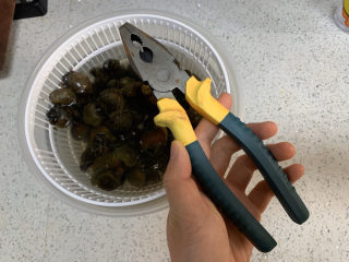 2、爆炒田螺肉,吐沙后的田螺要剪掉尾巴，可以用钳子或者厨房剪刀