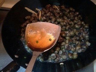 6、炒螺丝,放入一勺料酒。