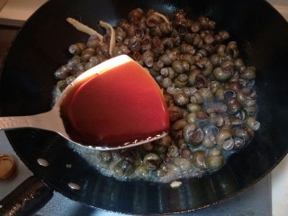 7、炒螺丝,放入一勺生抽。