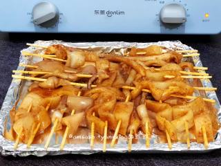 5、烤鱿鱼,先把烤盘用锡纸包好，包的目的是烤好之后烤盘不会弄脏，也不需要清洗，把腌制好的用鱿鱼用竹签串起来，依次把所有的鱿鱼串好