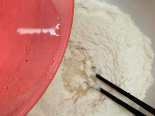 3、韭菜粉丝蒸饺,慢慢加水搅拌面团。