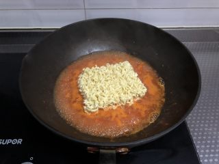 8、番茄浓汤面,开锅放入面饼，用筷子不停搅拌煮散