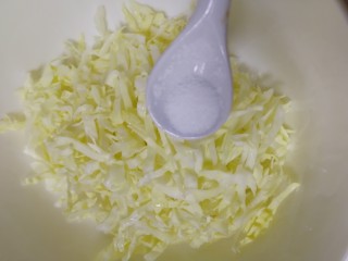3、鸡蛋卷心菜饼,撒上2g盐，拌匀。
