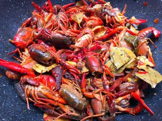 5、麻辣小龙虾,倒入小龙虾翻炒一会，炒至小龙虾微微的变色，加入适量盐和适量白糖翻炒均匀。