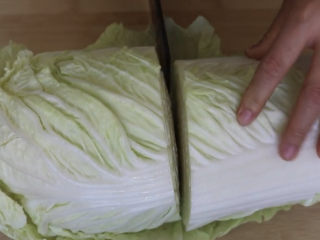 1、猪肉白菜水饺,买一棵大白菜，对半切开。做白菜饺我们只需要用到白菜叶多的部分，剩下一半刚好炒个酸辣白菜，下饭。