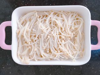11、蒜蓉粉丝烤花甲,捞出金针菇,把粉丝煎小段放入烤盘底部,上面盖上金针菇