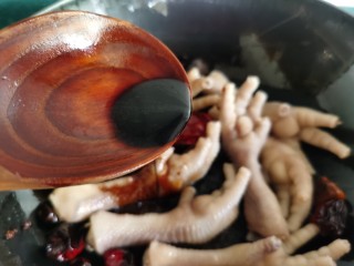 9、香辣卤鸡爪,倒入一勺生抽，再倒入老抽翻炒上色。