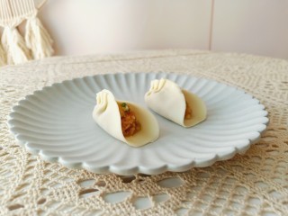 8、猪肉白菜水饺,拿一张饺子皮放上肉馅包起来。