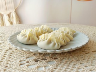 9、猪肉白菜水饺,拿一张饺子皮放上肉馅包起来。