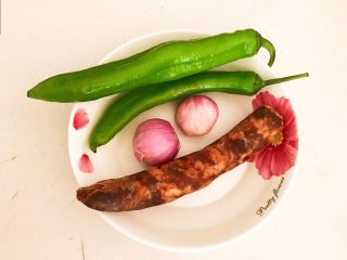 1、杂蔬腊肠炒饼,准备食材,尖椒清洗干净,毛葱剥皮,熟腊肠