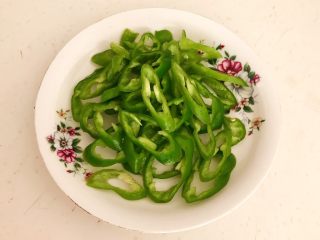 2、杂蔬腊肠炒饼,把尖椒去蒂去籽,切成辣椒圈