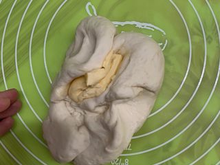 9、芝士肠仔包,把黄油揉进面团里。