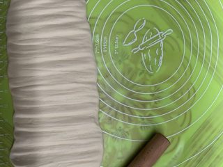 14、芝士肠仔包,敲成长舌的长条，来回敲扁它。