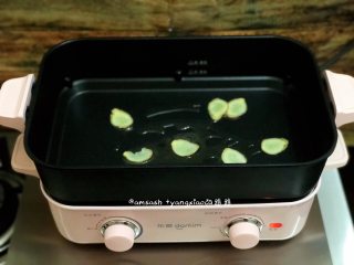 3、鲈鱼焖豆芽,老姜用专门洗刷食物的刷子洗刷掉表面的泥土,不用去皮,切成薄片,多功能锅倒入少许油,足够煎鲈鱼就好,把姜片放在多功能锅上