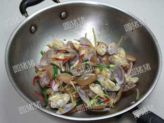 8、姜葱炒花蛤,至调味料均匀的裹上花蛤即可盛盘。