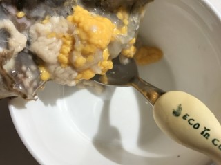 3、螃蟹炒年糕,盖中的蟹黄用勺子刮到碗中