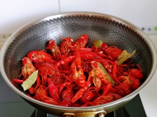 6、爆炒小龙虾,再倒入焯水的龙虾，小火翻炒均匀。