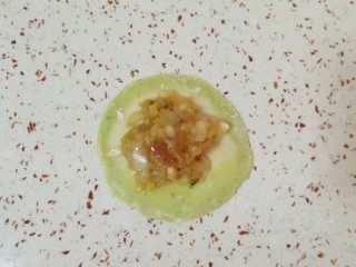 15、猪肉白菜水饺,取一个擀好的饺子皮放上馅。