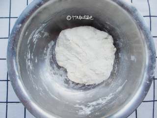 2、家常韭菜饼,用筷子搅成絮状,由于面粉吸水性不同,温水不要一次倒入,先倒入大半看情况再增减。揉成很软的面团,不用揉成很光滑,因为面团特别软,盖上保鲜膜发酵40分钟