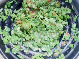 4、家常韭菜饼,加入一勺油,盐、辣椒粉、鸡粉、胡椒粉搅拌均匀