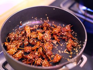 11、秘制牙签肉,撒上余下的生白芝麻翻炒均匀后出锅