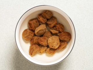 1、梅香秋意小排,将话梅加入热水泡着胀发。
