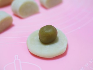 13、冰皮月饼,揉成饼状，放入搓成圆球的馅料，包好收口。放手粉中滚一圈。