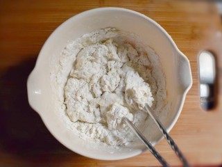 2、海米韭菜鸡蛋水饺,加入适量的温水,用筷子搅拌成絮状。