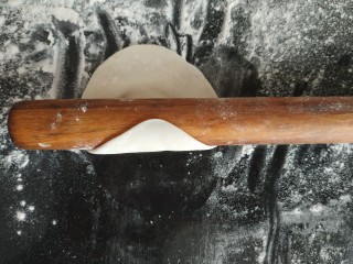 13、咸蛋黄糯米烧麦,用擀面杖从圆的边缘往中间擀，用力均匀，擀一下，用另一只手拿饺子皮转一下，把一圈都擀到，这样就是饺子皮，中间厚边缘薄的状态；